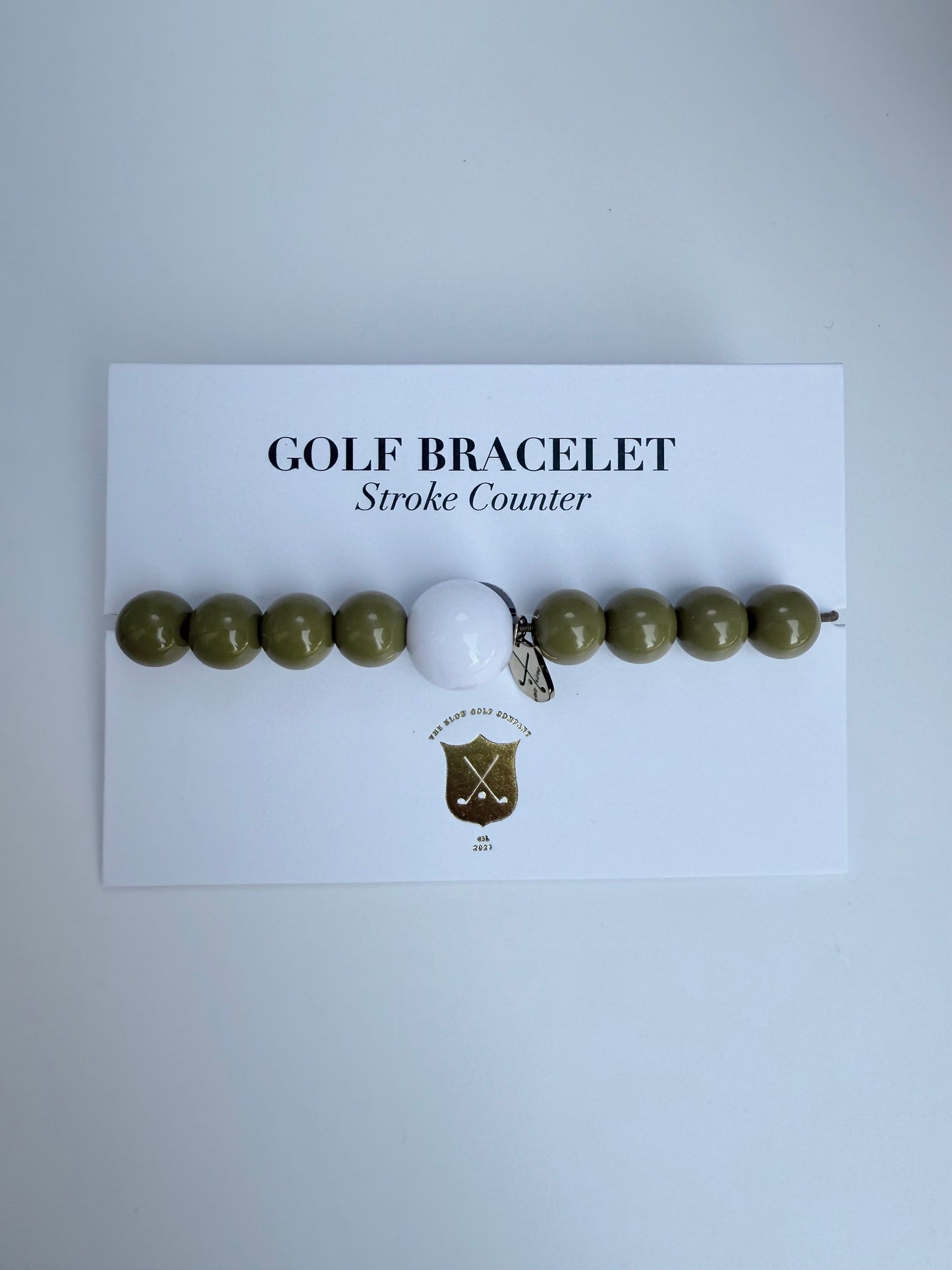 Golf bracelet with a golf ball charm on a white card with text