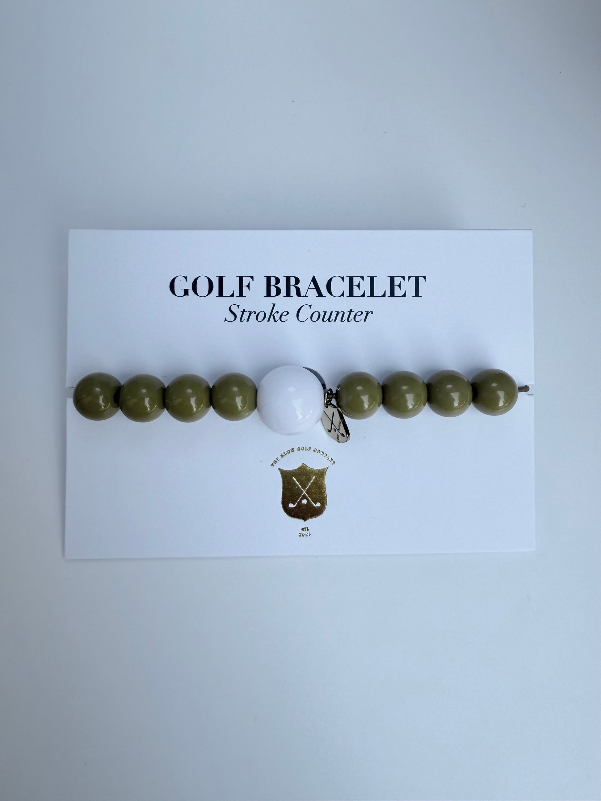 Golf bracelet with a golf ball charm on a white card with text