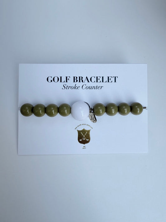 Golf bracelet with a golf ball charm on a white card with text