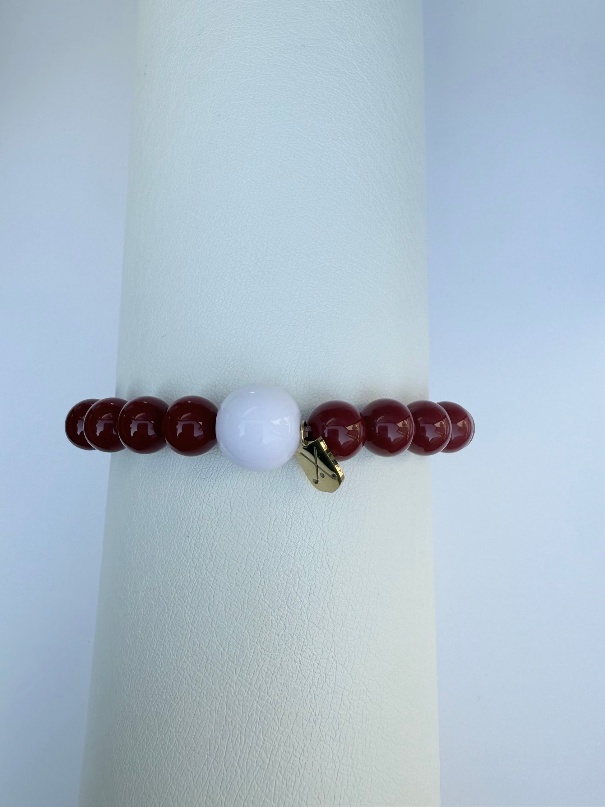Bracelet with red and white beads on a white background