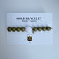 Golf bracelet with a golf ball charm on a white card with text
