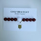Golf bracelet with red beads and a white ball on a card labeled 'Golf Bracelet Stroke Counter' against a light gray background.